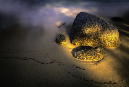 Alone big stone lying on a sandy beachの写真素材