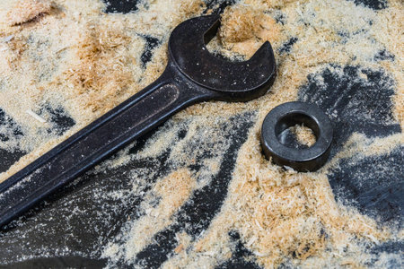 Nut wrench laid in wood shavings with a metal backingの写真素材