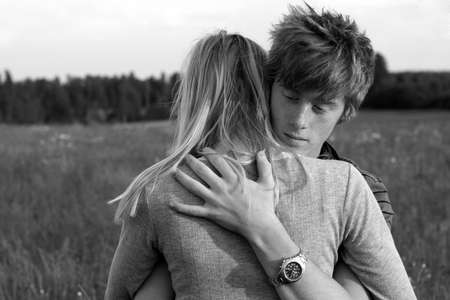 Young teenage couple hugging eachother on a fieldの写真素材