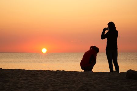 These are shadows of two girls waiting for the sunrise.の写真素材