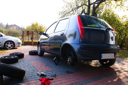 This is a man changing the wheel in the car