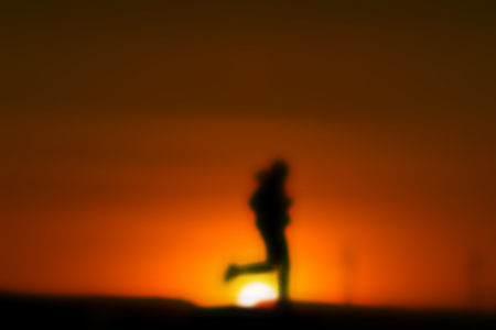 Sunset silhouette of a girl runningの写真素材