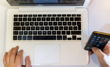 Using mobile Devices Laptop and Mobile phone top view, Vienna Austria 9.11.2017のeditorial素材