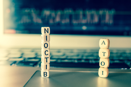 Small dices on laptop showing Bitcoin and IOTA lettersの写真素材