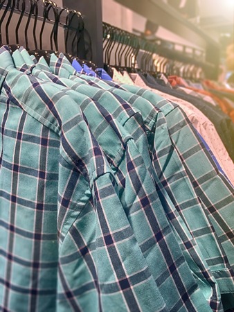 Clothes hanger row holding shirtsの写真素材