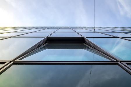 Modern slate Glass building with single open window against skyの写真素材