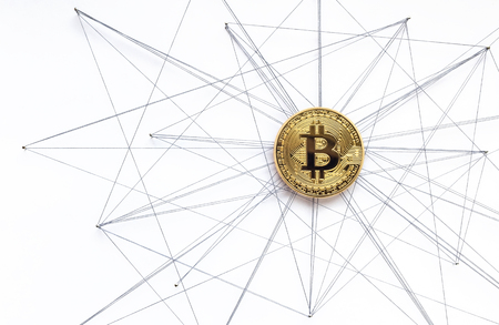 Physical Bitcoin suspended in sewing thread and pins isolated blockchain network conceptの写真素材