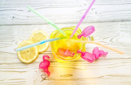 Ice cold Lemonade in glass jar with straws and icy plastic flamingosの写真素材