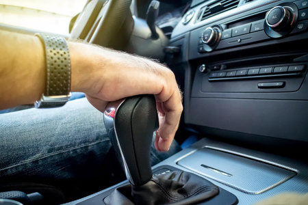 Young man driving modern car hand on gear shift