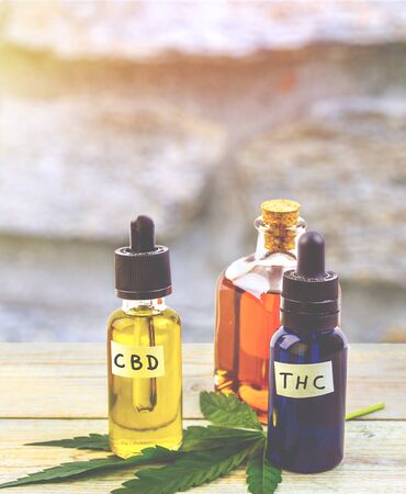 Medicinal cannabis with THC , CBD and hemp seed oil extracts in bottle on wooden tableの写真素材
