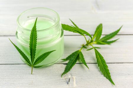 CBD Cannabis Hemp topical cream balm with cannabis leafs on wooden tableの写真素材