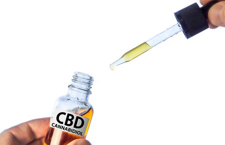 Hand holding Pipette with cannabis oil isolated on white, CBD Hemp oil, medical marijuana oil conceptの写真素材
