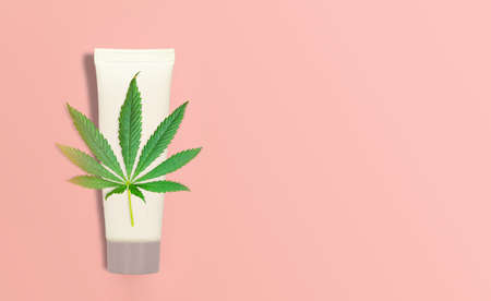 CBD Cannabis Hemp topical cream balm with cannabis leaf on pink backdropの写真素材