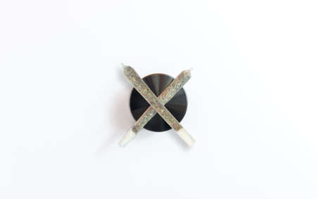 Medical marijuana joints on cannabis grinder isolated on whiteの写真素材
