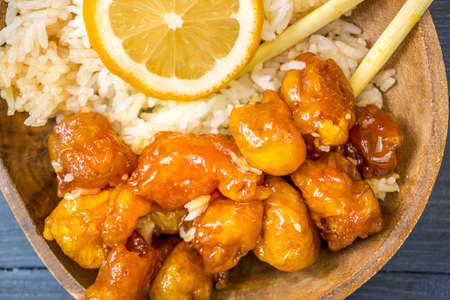 Chinese Food Sweet and Sour, Orange or Lemon Chicken in wooden bowl on rustic tableの写真素材