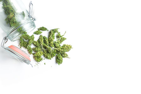 Jar with Medical Marijuana flower buds spill on white background with copy spaceの写真素材