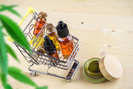 Cannabis CBD oil shopping concept, Medical marijuana oils in miniature shopping cartの写真素材