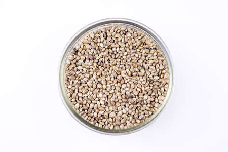 Cannabis seeds in glass bowl isolated on white rich in protein and healthy fatsの写真素材