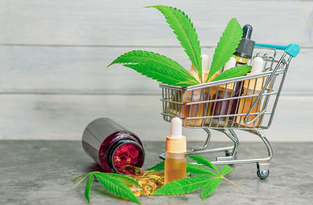 Supermarket trolley basket with cannabis Cbd or THC oils capsules, CBD purchasing conceptの写真素材