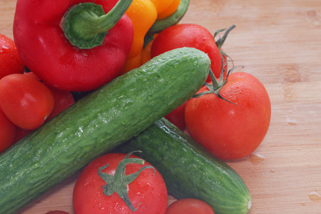 Paprika, tomatoes, cucumber fresh and washed on a wooden boardの写真素材