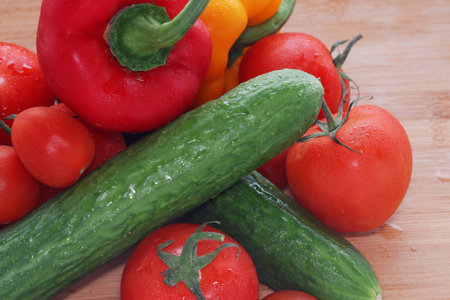 Paprika, tomatoes, cucumber fresh and washed on a wooden boardの写真素材