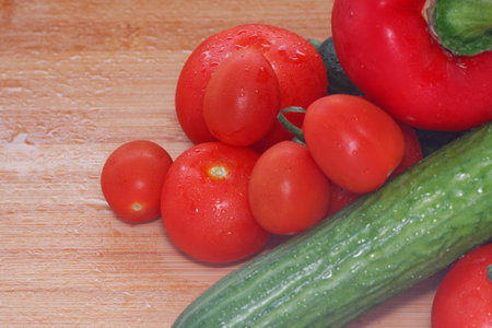 Paprika, tomatoes, cucumber fresh and washed on a wooden boardの写真素材