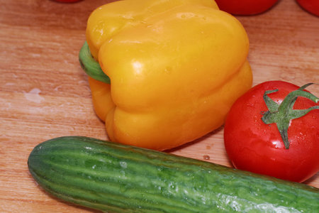 Paprika, tomatoes, cucumber fresh and washed on a wooden boardの写真素材