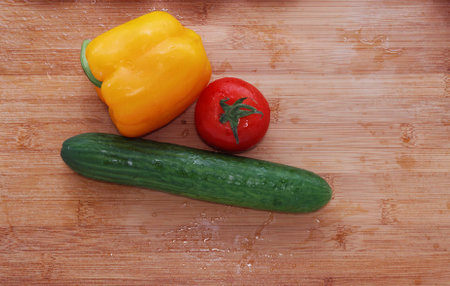 Paprika, tomatoes, cucumber fresh and washed on a wooden boardの写真素材