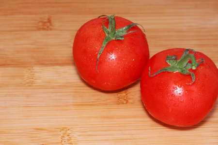 Tomatoes on a wooden table. Fresh and just washed...の写真素材