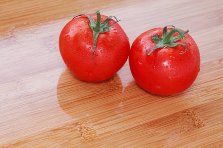 Tomatoes on a wooden table. Fresh and just washed...の写真素材