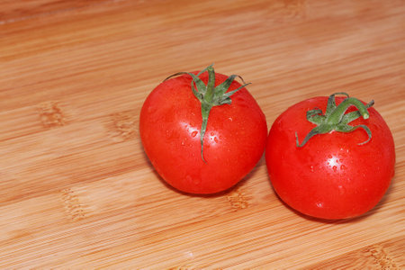 Tomatoes on a wooden table. Fresh and just washed...の写真素材
