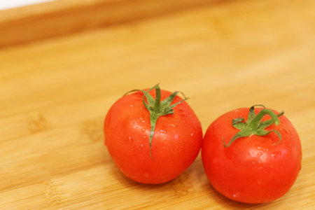 Tomatoes on a wooden table. Fresh and just washed...の写真素材