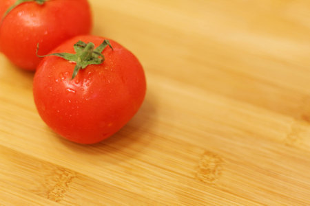 Tomatoes on a wooden table. Fresh and just washed...の写真素材