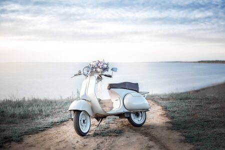 A large beautiful Bridal bouquet of white roses and peonies. The wedding bouquet is lying on a retro bike.の写真素材