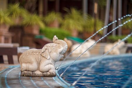Luxury outdoor pool and Elephant water. Elephant statues spray water from a swimming pool. Elephant Concrete. Elephant statue by the pool.の写真素材