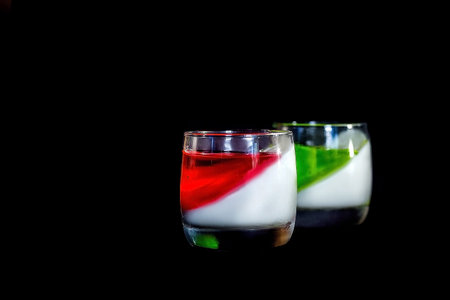Homemade yogurt with berry jelly or yogurt in glasses. Close up. Dark background.