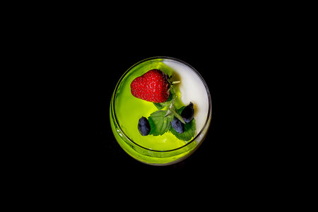 Homemade yogurt with green berry jelly or yogurt in glasses is served with fresh strawberries,...