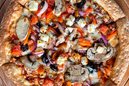 Homemade pizza with vegetables lies on a dark background. Close up. The view from the top.の写真素材
