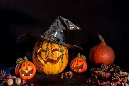 Carved Pumpkins for Halloween, Jack's head is on the table. Pumpkin in a witch's hat. Dark background.の写真素材