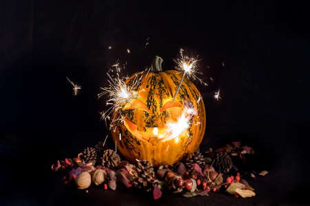 Carved pumpkins for Halloween, Jack's head is on the table. Fireworks in a pumpkin. Dark background.の写真素材