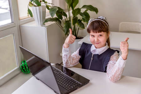 The girl learns (communicates, talks) through a computer / laptop. Back to school concept.の写真素材