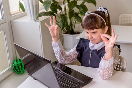 The girl learns (communicates, talks) through a computer / laptop. Back to school concept.の写真素材