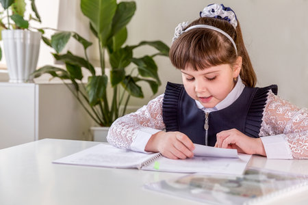 A girl pupul sits at a desk in the classroom and reads a book. Back to school conceptの写真素材