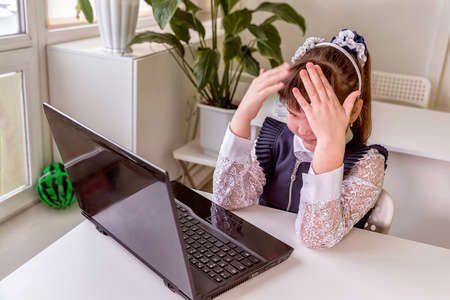 The girl learns (communicates, talks) through a computer / laptop. Back to school concept.の写真素材