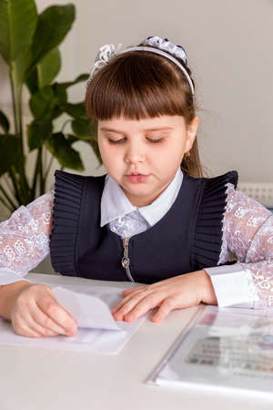 A girl pupul sits at a desk in the classroom and reads a book. Back to school conceptの写真素材