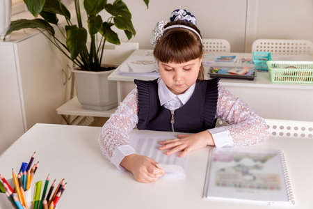 A girl pupul sits at a desk in the classroom and reads a book. Back to school conceptの写真素材