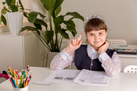 A girl pupul sits at a desk in the classroom and reads a book. Back to school conceptの写真素材