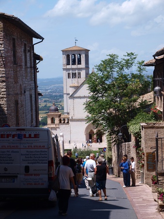 A street in Assisi, Italy leading to the Basilica of Saint Francis of Assisi with crowds of people rushing to the sanctuary.のeditorial素材