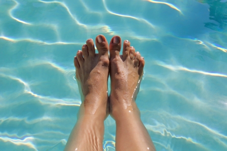 clear transparent water in pool with footsの写真素材