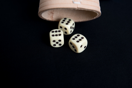 White dice with dice cup on black backgroundの写真素材